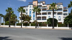 A multi-story hotel with balconies, palm trees, and a clear sky. - LA MARINA 3 21 - Two Bedroom Apartment, Sleeps 5 (Punta del moral)