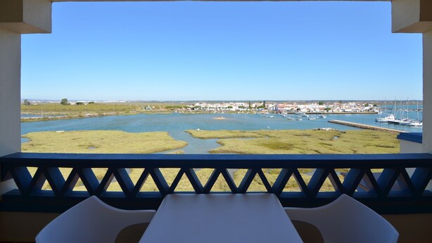 A balcony with a view of a marina and a town.