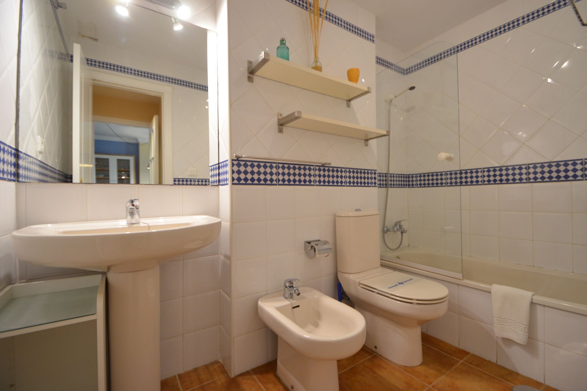 A bathroom with a sink, bidet, toilet, and bathtub.