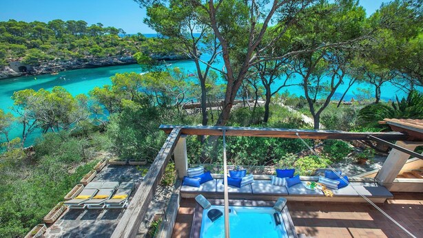 A rooftop pool area with a hot tub, lounge chairs, and a view of a turquoise sea and rocky coastline. - Stunning Seafront Villa in the Mondragó National Park, Amazing Views & Direct Access to the Beach! (Cala Mondrago)