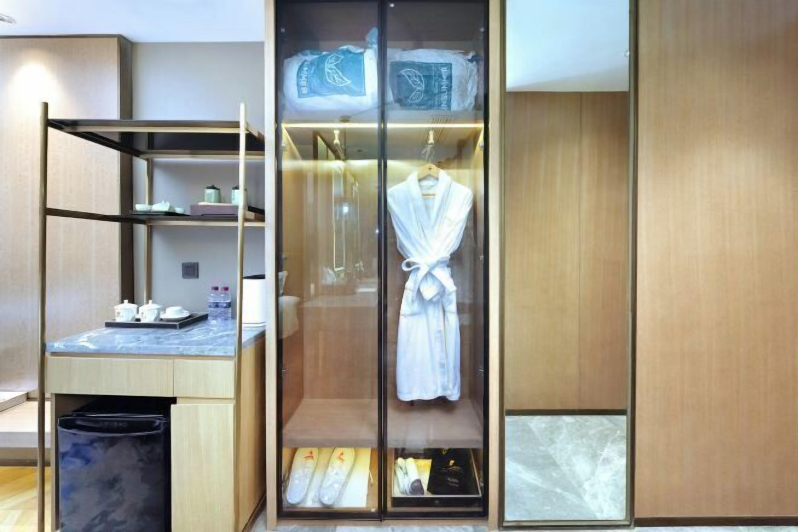 A modern bathroom with a glass-enclosed shower, a wooden vanity with a marble countertop, and neatly arranged toiletries.