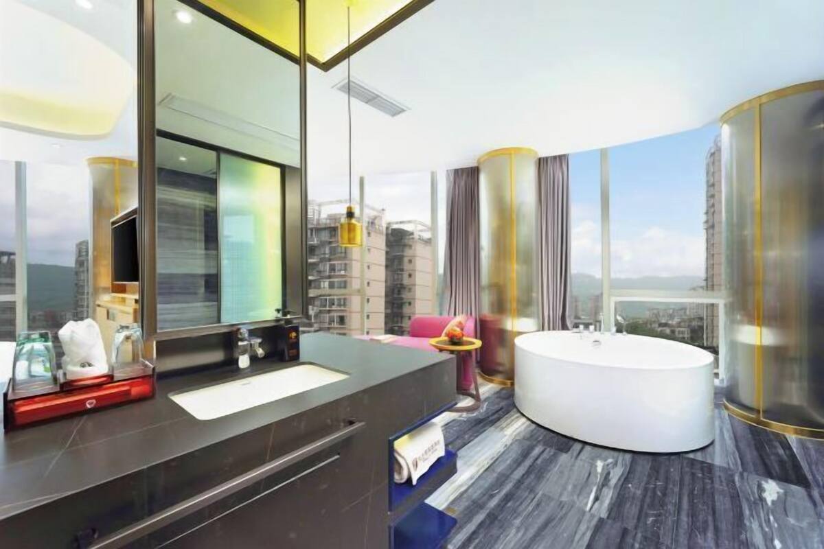 Un baño moderno con un espejo grande, una bañera y un lavabo con tocador.
