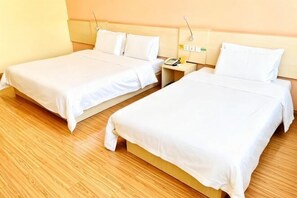 Two single beds with white bedding, wooden flooring, and a bedside table with a lamp. - 7Days Inn Chain Hotel (Guangrao Sunwu Road) (Guangrao)