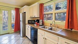A kitchen with a refrigerator, microwave, coffee maker, and sink. - The Rhododendron House is a spacious cottage in Waynesville, NC. It is ideal for families traveling with younger and older children and longer term stays. This open floor plan, 1000sq foot cottage is a stand alone building and has ample space to spre (Waynesville)