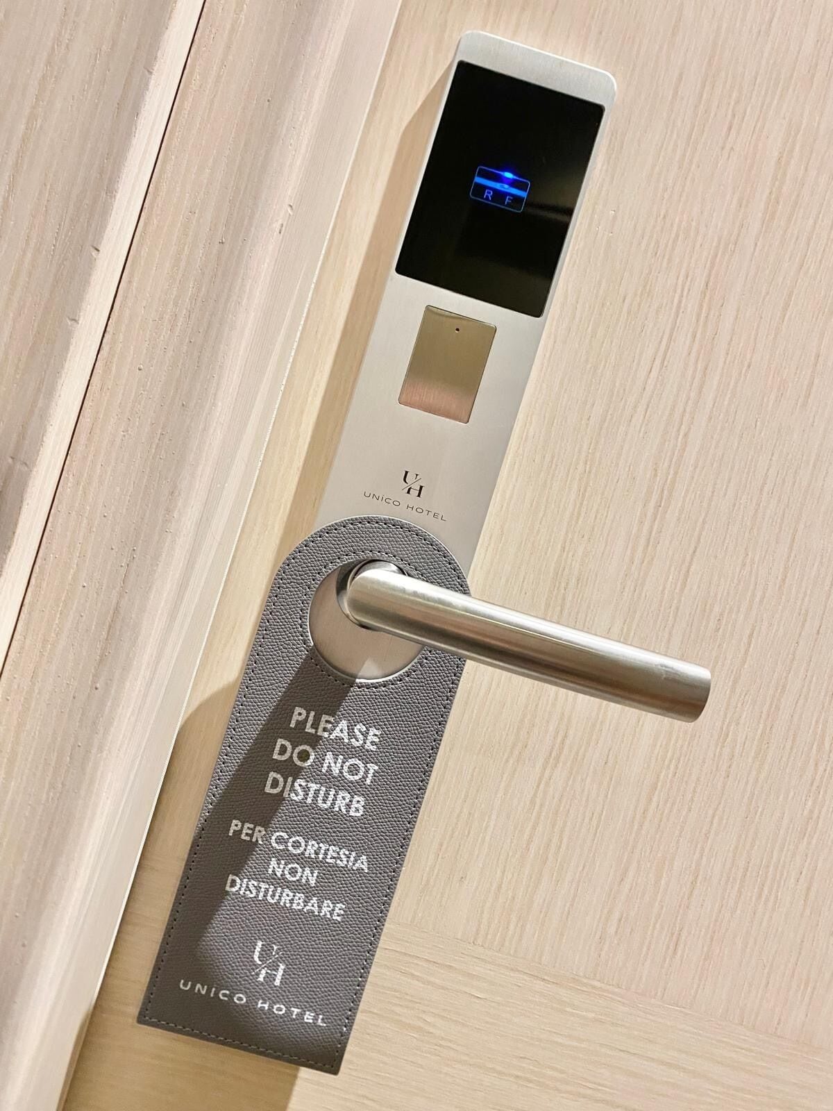 A hotel room door with a digital lock and a keyhole.