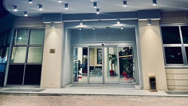 L’extérieur de l’hôtel UNICO se distingue par une enseigne lumineuse bien visible, une grande entrée en verre et une architecture moderne.