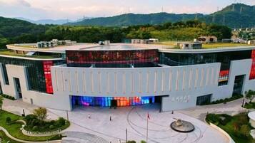 A modern building with a curved facade, a central courtyard, and a flagpole.