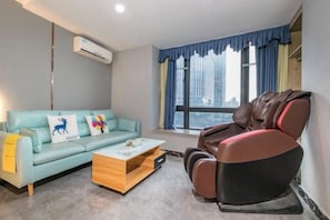 Une pièce comprenant un canapé, un fauteuil de massage et une table basse.