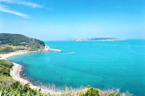 A coastal landscape with a beach, clear blue sea, and distant land. - Jinfan City Hotel (Fuzhou)