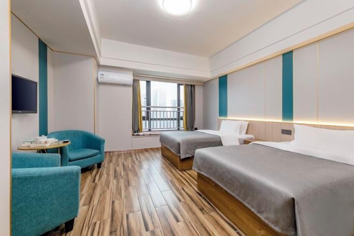 Une chambre d’hôtel avec un lit, une chaise, une petite table et une fenêtre donnant sur un paysage agréable.