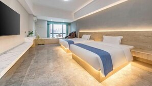 A modern hotel room with two beds, a flat-screen TV, a desk, and a window with curtains. - Jinfan City Hotel (Fuzhou)