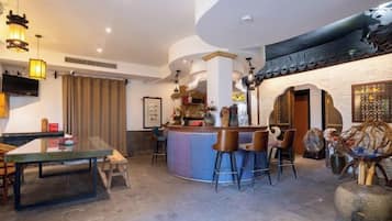 A modern interior with a bar area, dining space, and a kitchen.