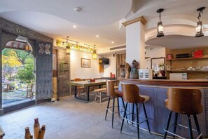 Restaurante com área de bar, assentos e vista através de uma grande janela.