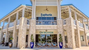 A two-story hotel with balconies, a sign reading "Euphoria On Vacation," and outdoor seating.