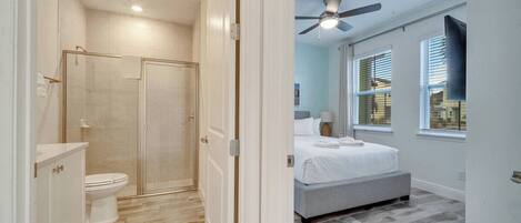 A modern bathroom with a shower, toilet, and vanity.