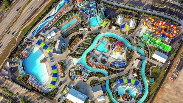 An aerial view of a theme park with multiple water slides, pools, and themed areas.