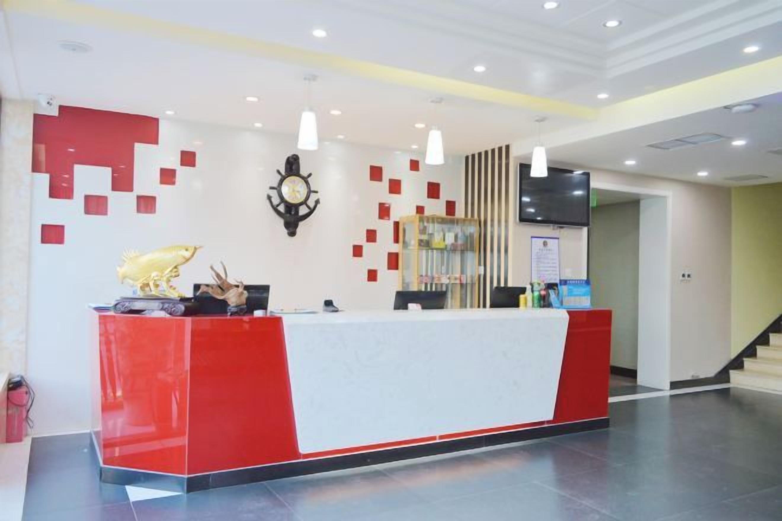 A reception desk with a red and white color scheme, a clock, and a modern design.