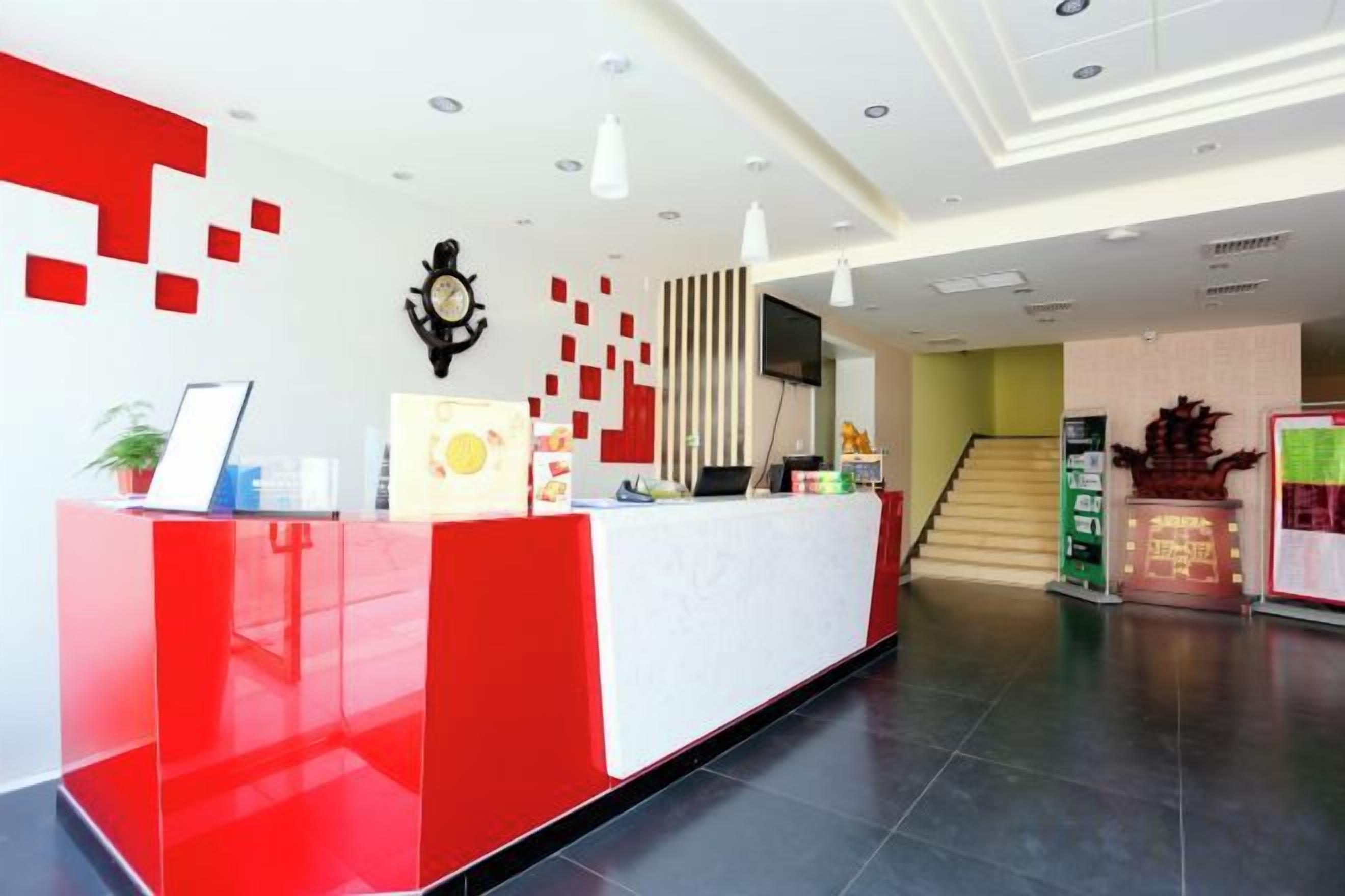 Ein Empfangsbereich im modernen Design, mit einer Rezeption, einer Uhr und einer Treppe zu einer anderen Etage.