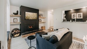 Een moderne woonkamer met een open haard, een bank en een salontafel.