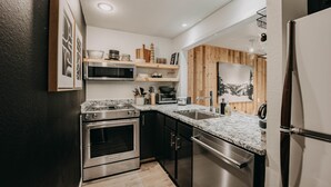 Een moderne keuken met roestvrijstalen apparatuur, houten details en een granieten aanrecht.