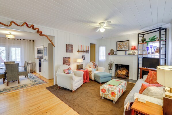 A cozy living room with a fireplace, a ceiling fan, and a TV. - Unwind Fireside & Walk to Dtwn! Tyron Retreat (Tryon)
