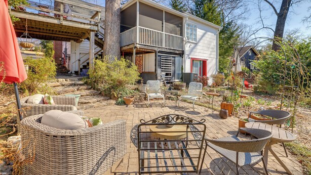 A covered patio with wicker furniture, a small table, and chairs. - Unwind Fireside & Walk to Dtwn! Tyron Retreat (Tryon)
