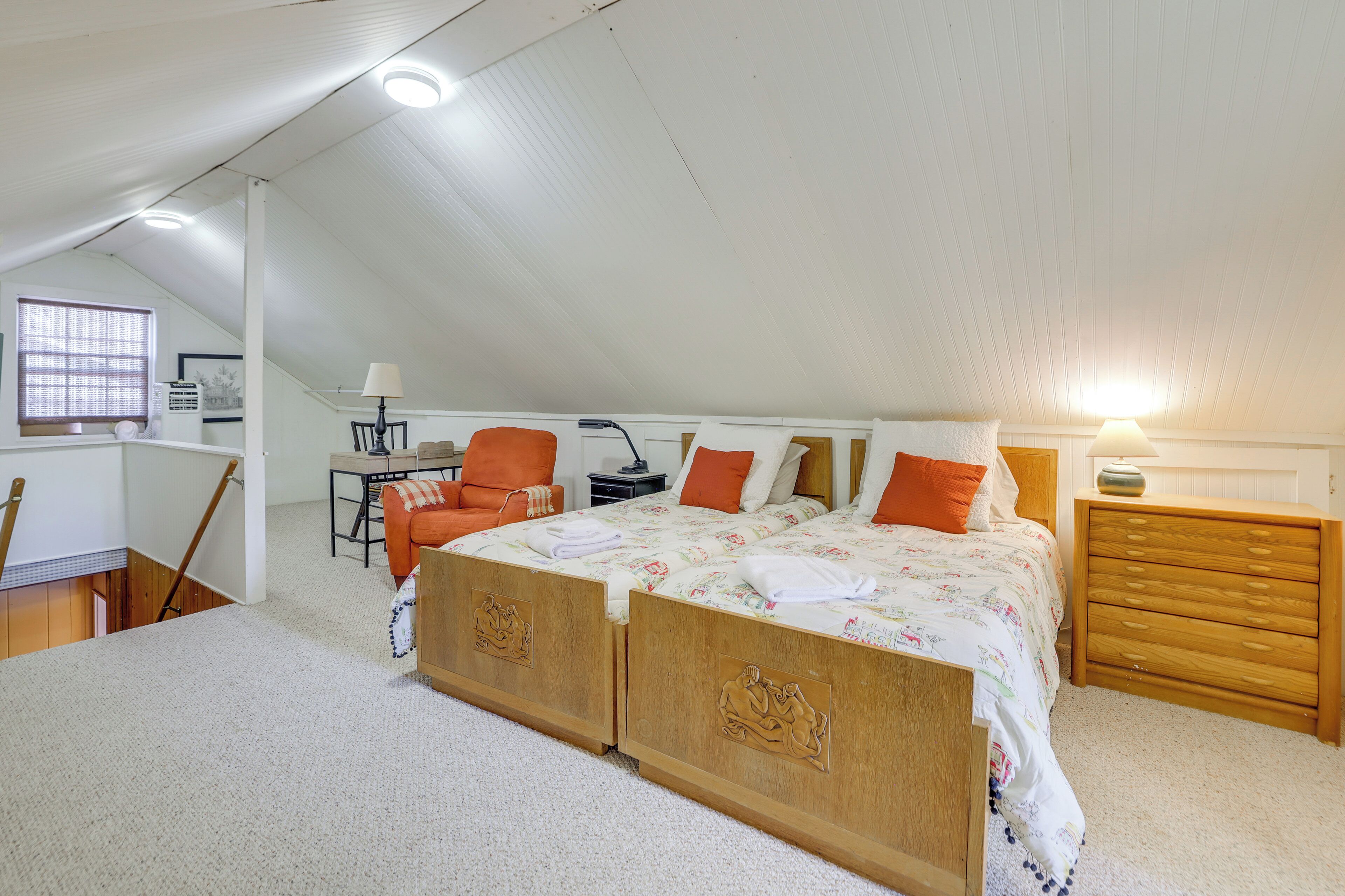 A bedroom with a large bed, a desk, and a chair.