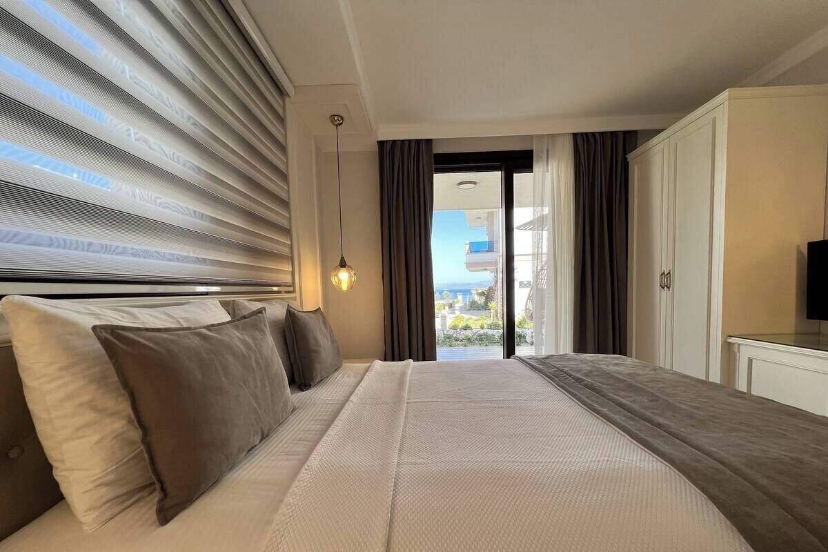 A hotel room with a large bed, a television, and a view of the outdoors.