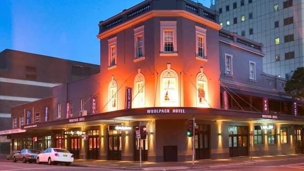 A historic hotel with a classic facade, multiple windows, and a prominent sign reading "WOODPACK HOTEL." - Woolpack Hotel (Parramatta)