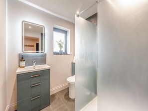 Un bagno con specchio, lavandino, WC e doccia.