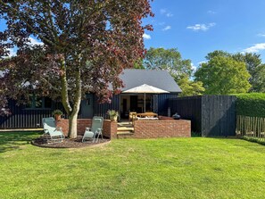 A backyard with a patio, a barbecue grill, and a covered seating area. - 1 bedroom accommodation in Eye (Eye)