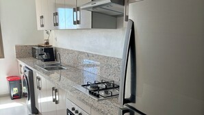 Una cucina moderna con elettrodomestici in acciaio inossidabile, piani in granito e fornello a gas.