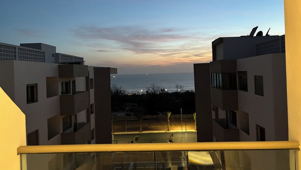 Un edificio moderno con un balcone che si affaccia su un corpo d'acqua al crepuscolo.