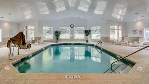 An indoor swimming pool with clear water, surrounded by white chairs and potted plants. - BEAUTY on The Sound!  Port Royal Hilton Head, Gorgeous, Peaceful Sleeps 6/2br2ba (Hilton Head)
