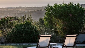 Two lounge chairs facing a body of water with mountains in the background. - Paradiso Vintage Villa: Traditional 1944 Gem (Pili)