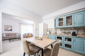 Une cuisine moderne avec des armoires de couleur turquoise, un comptoir en marbre et des appareils électroménagers intégrés.