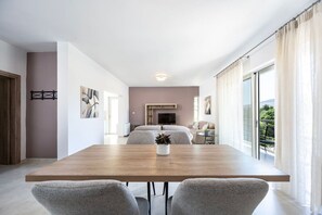 Un salon moderne avec une table à manger en bois, des canapés gris et un téléviseur.