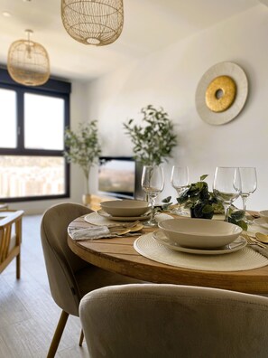 Enjoy meals in this stylish dining area with a round table, comfortable chair, and beautiful green centerpiece.