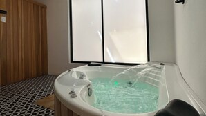 A modern bathroom with a freestanding bathtub, a wooden floor, and a large window. - Casa Shakti a paradise in the city (Mérida)
