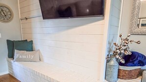 Una chimenea de ladrillo blanco con un televisor de pantalla plana montado encima.