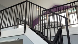 Un intérieur moderne avec un escalier, une verrière et un espace cuisine.