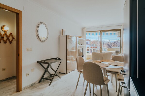 Une cuisine moderne avec un coin repas, un réfrigérateur et une vue sur la ville.