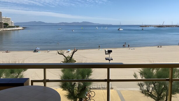 A beach view with a clear sky, calm sea, and distant mountains. - Apartment 'Platja Mar 2' with Sea View and Balcony (L'Escala)