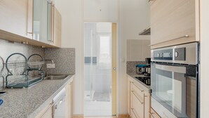 A modern kitchen with granite countertops, stainless steel appliances, and wooden cabinets.