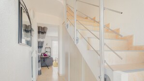 A staircase with metal railings, a mirrored wall, and a door leading to another room.
