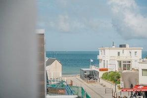 Un bâtiment situé sur la côte, avec vue sur la mer, un drapeau et une enseigne sur laquelle on peut lire « LA VIECI ».