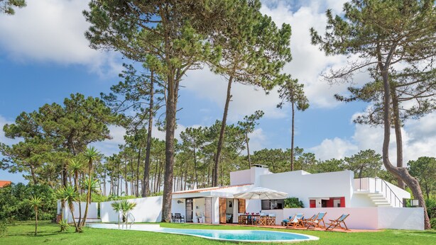 A modern house with a swimming pool, outdoor seating, and tall trees. - Apartment 'Cerca Do Altinho' with Private Pool, Private Terrace and Wi-Fi (Vila Nova de Milfontes)