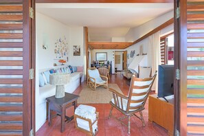 A spacious living room with a sofa, chairs, a television, and a dining area. - Apartment 'Cerca Do Altinho' with Private Pool, Private Terrace and Wi-Fi (Vila Nova de Milfontes)