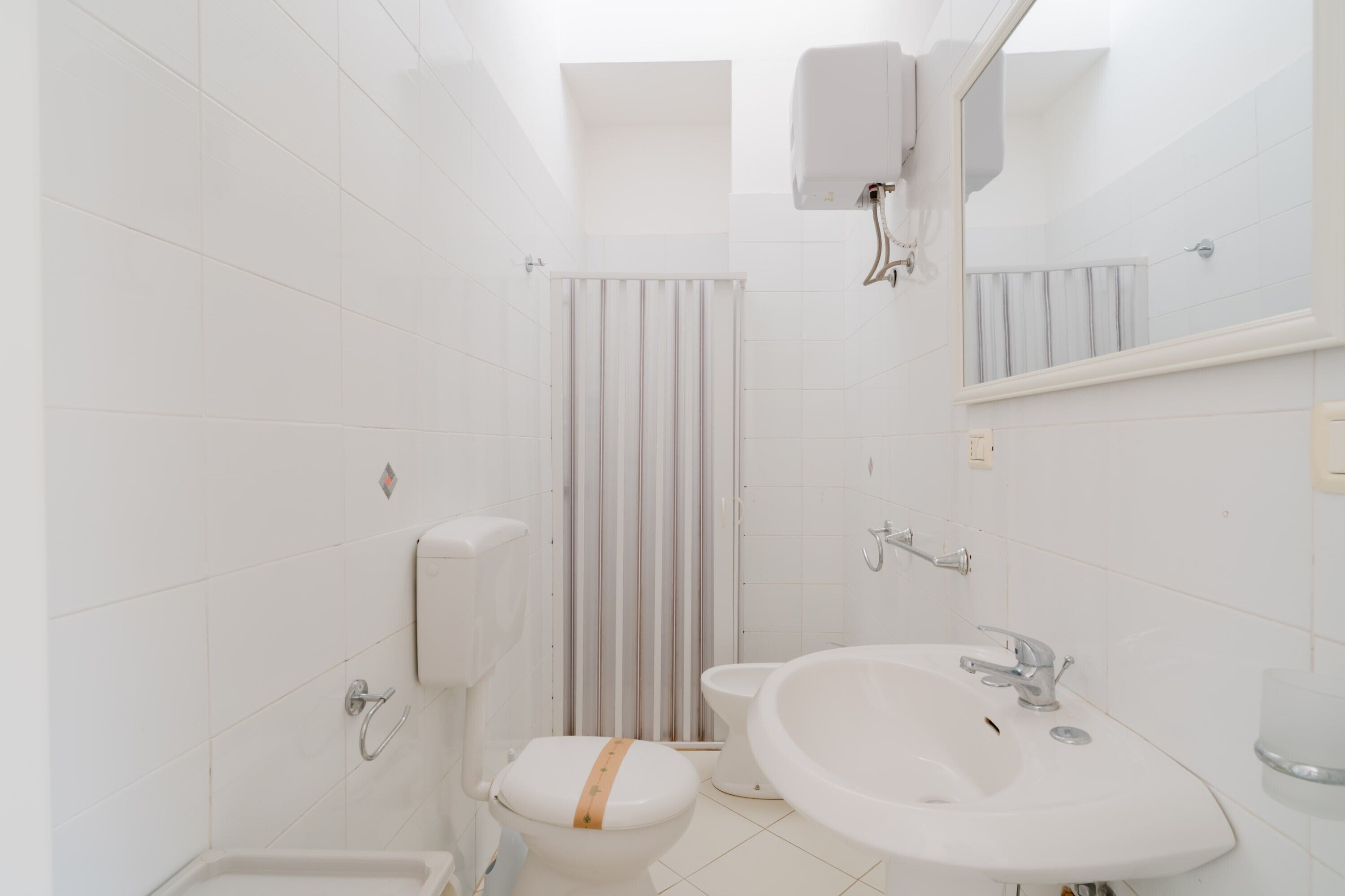 Ein Badezimmer mit Toilette, Waschbecken und Duschvorhang.