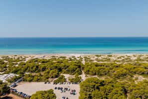 An aerial view of a coastal area with a beach, parking lot, and dense greenery. - Holiday Home 'Fontanelle' (Fontanelle)